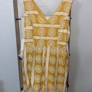 Yellow and white floral patterned romper. Zip up back